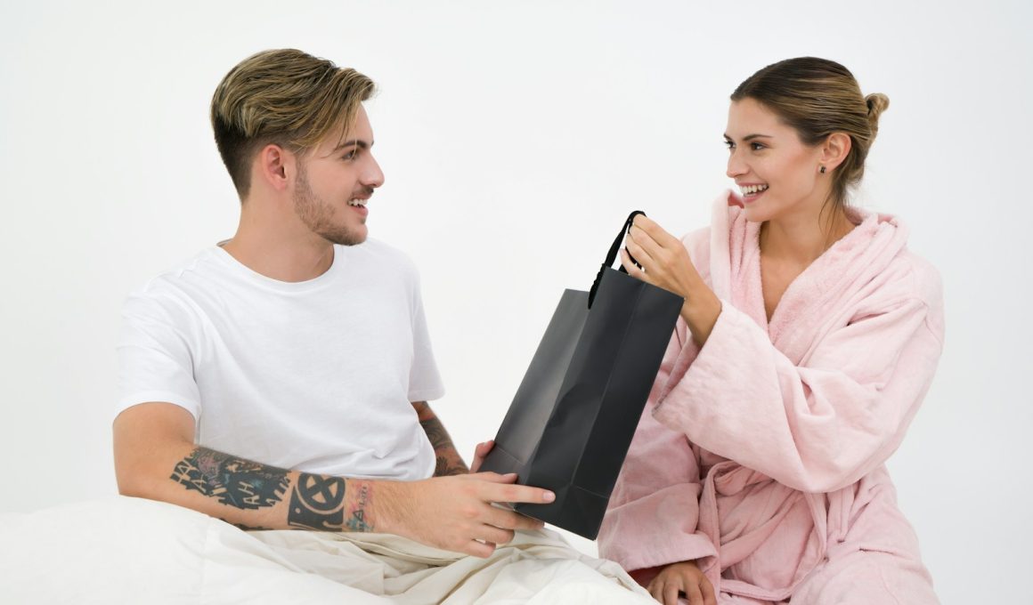 woman holding black paper bag sitting in front of the man