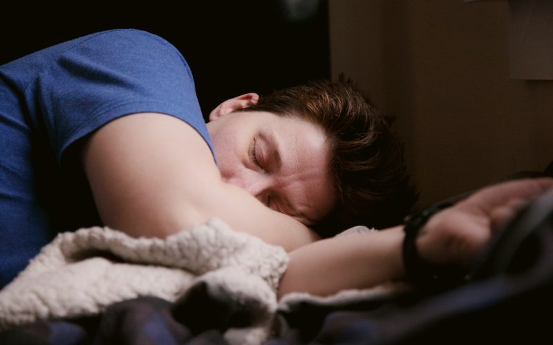 woman in blue shirt lying on bed