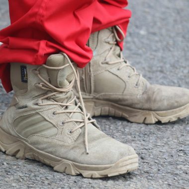 person in red pants and brown leather lace up boots