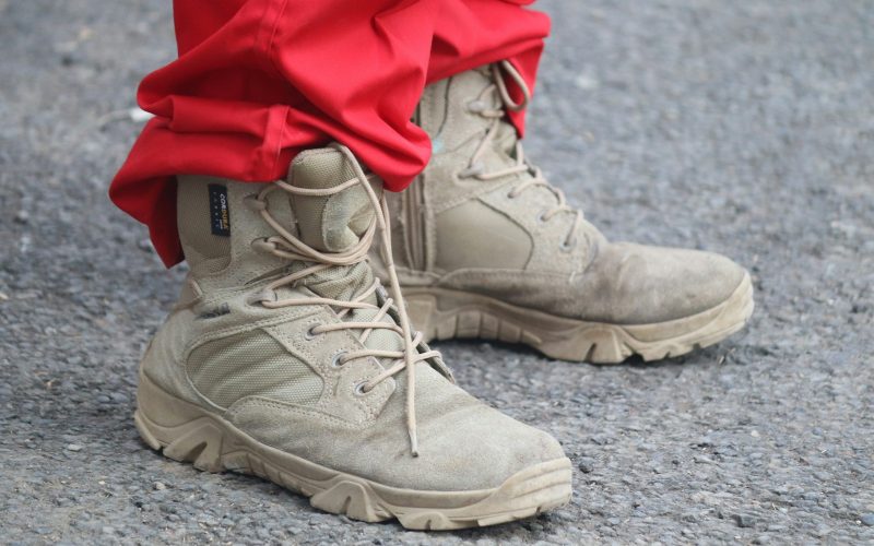 person in red pants and brown leather lace up boots