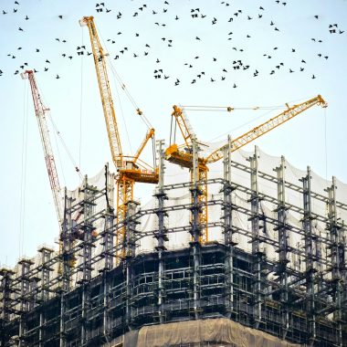 low angle photography of cranes on top of building