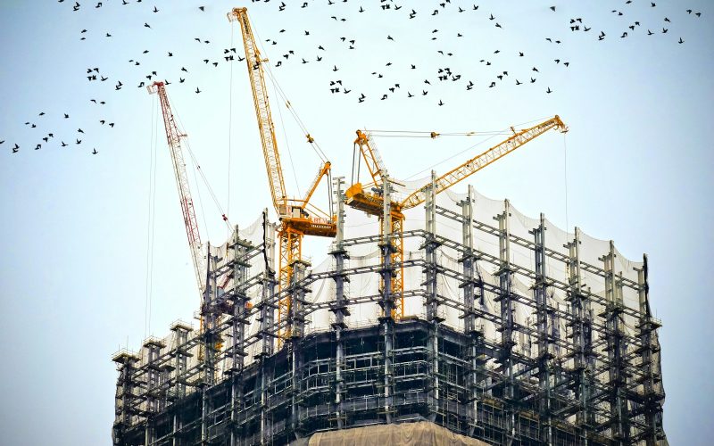 low angle photography of cranes on top of building