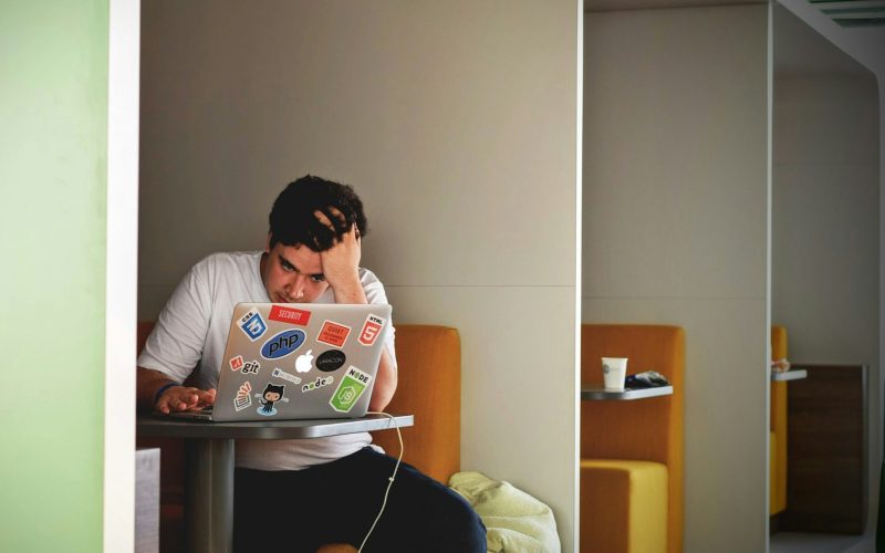 man wearing white top using MacBook