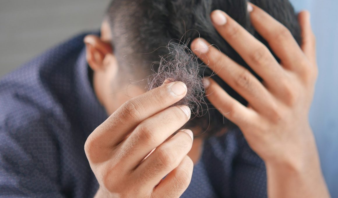 a man is combing his hair with his hands