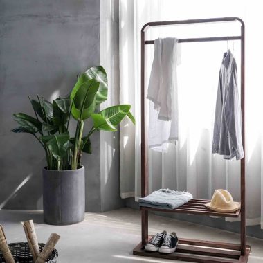 gray dress shirt hang on brown wooden rack in front of window with white curtain