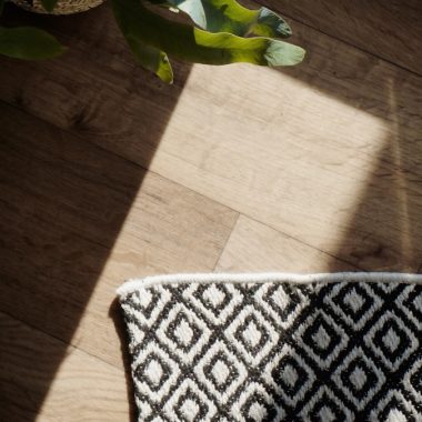 a vase of flowers sitting on top of a wooden floor