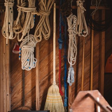 white and blue rope hanged on brown wooden wall