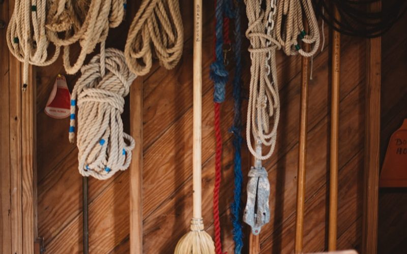 white and blue rope hanged on brown wooden wall