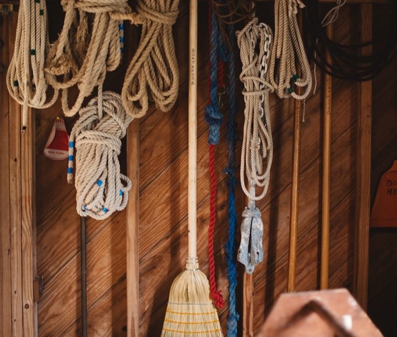 white and blue rope hanged on brown wooden wall