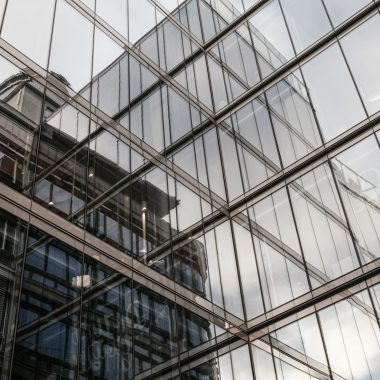 the reflection of a building in the windows of another building