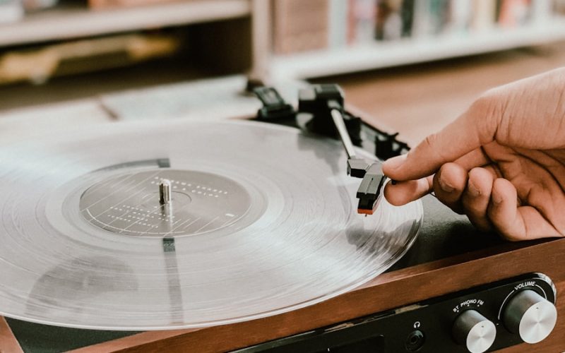 person playing record on Victrola turntable