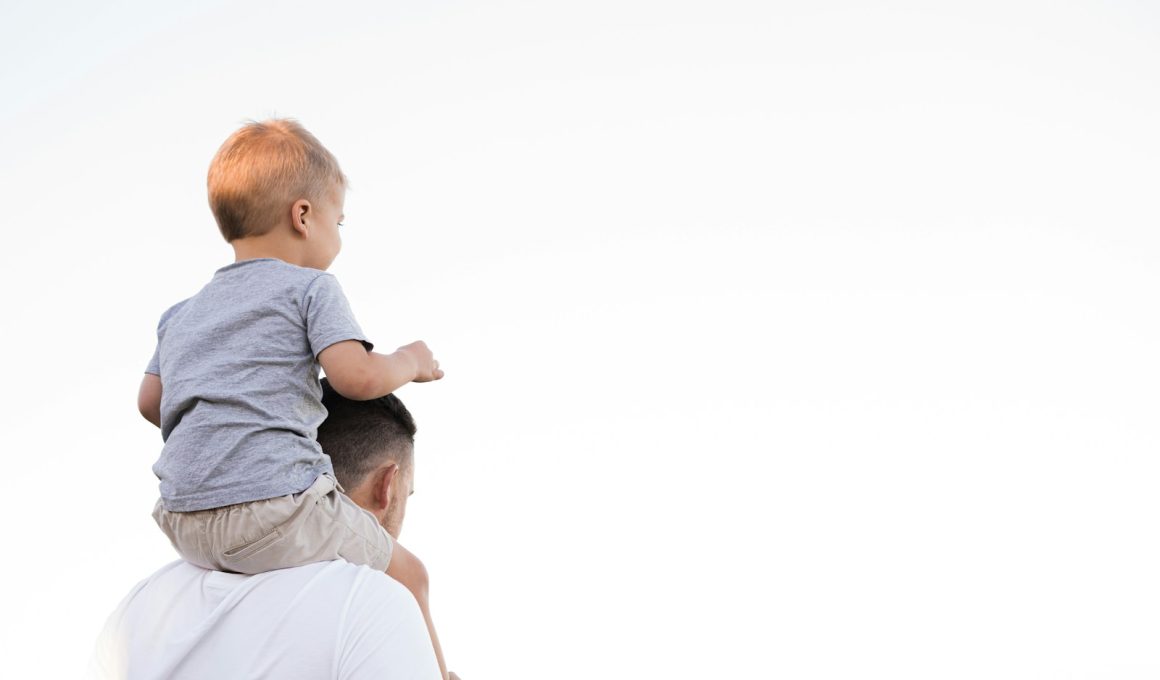 man in white shirt carrying boy