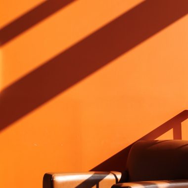a chair sitting in front of an orange wall