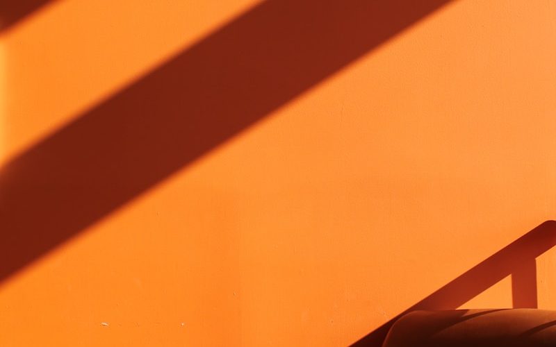 a chair sitting in front of an orange wall