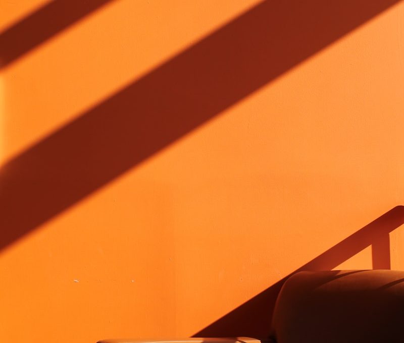 a chair sitting in front of an orange wall