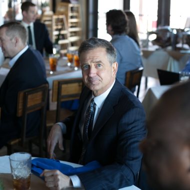 man in black suit jacket sitting on chair
