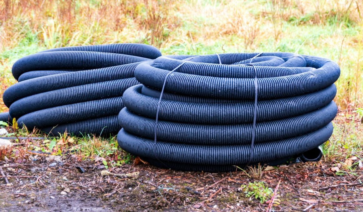 Two coiled black drainage pipes on the ground.