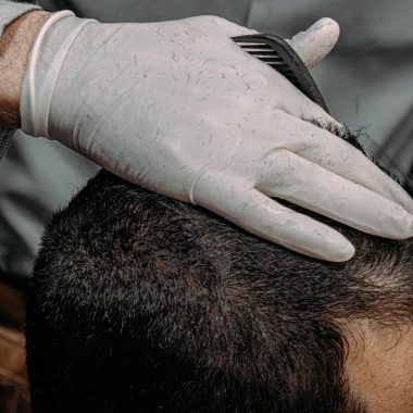a close up of a person cutting another persons hair
