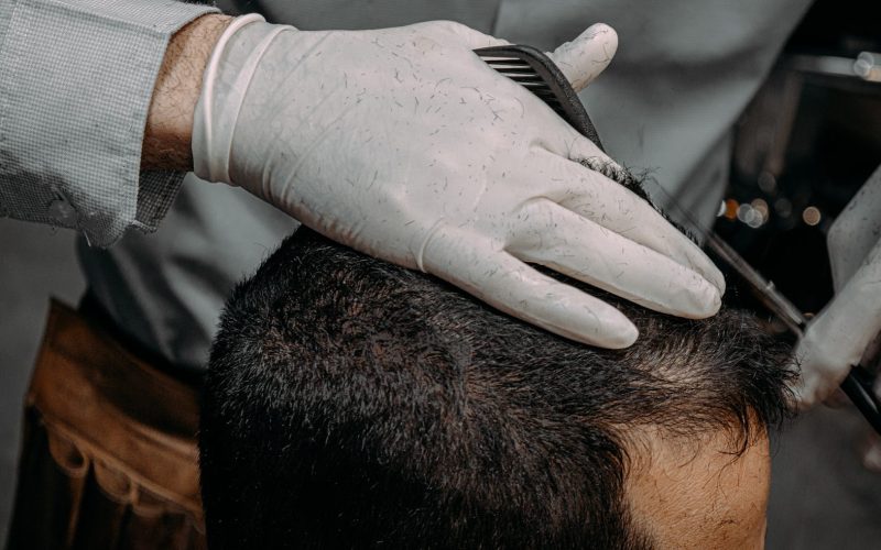 a close up of a person cutting another persons hair
