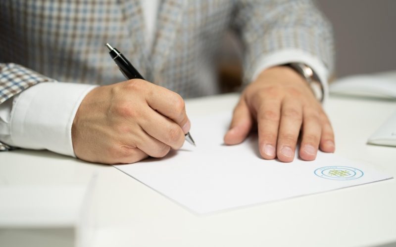 Man die zijn loonstrook bestudeert om bruto naar netto salaris te berekenen