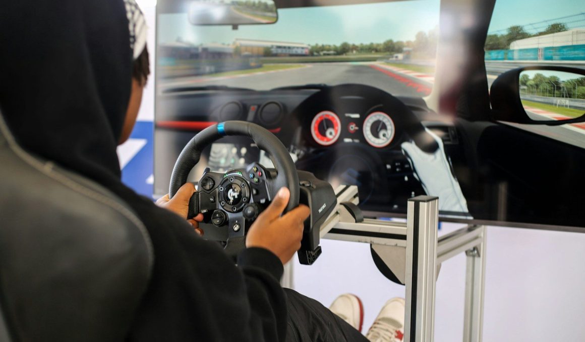 a person in a black hoodie driving a car