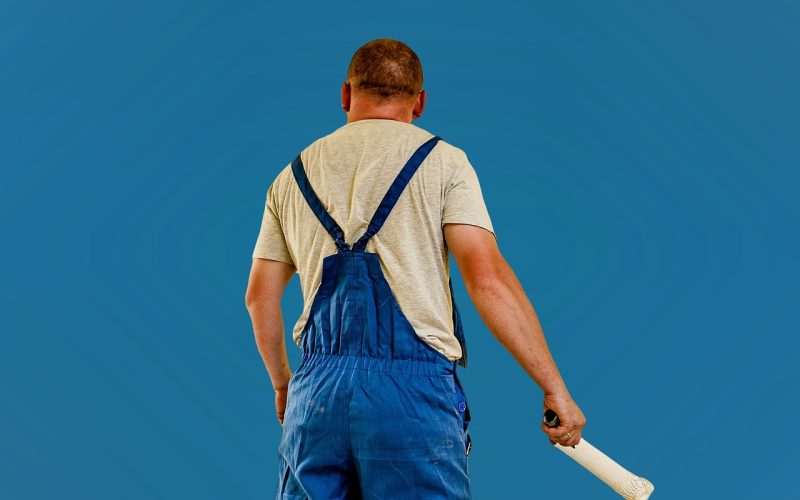 Een schilder die een muur renovatieproject afwerkt met een verfroller