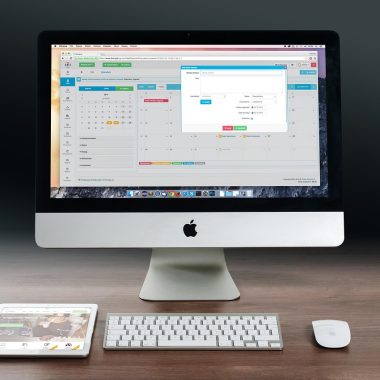 Zzp'er die aan zijn bureau zijn financiën berekent met een laptop en notitieblok