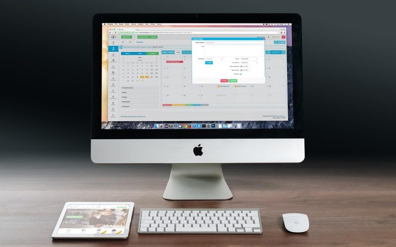 Zzp'er die aan zijn bureau zijn financiën berekent met een laptop en notitieblok