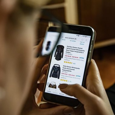 Man die kleding vergelijkt bij online winkels op laptop