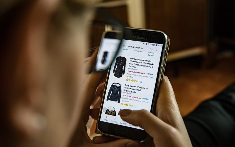 Man die kleding vergelijkt bij online winkels op laptop