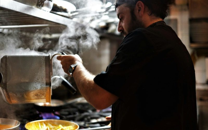 man in black t-shirt holding a cup