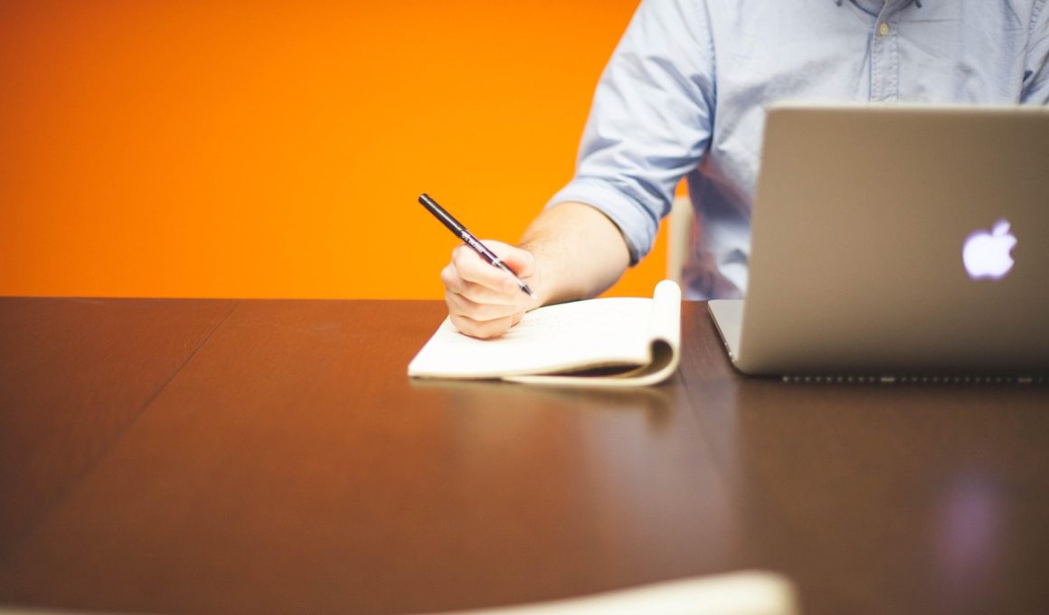 Zelfstandige man werkt geconcentreerd achter zijn laptop op een opgeruimde werkplek