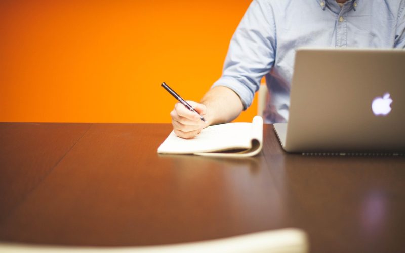 Zelfstandige man werkt geconcentreerd achter zijn laptop op een opgeruimde werkplek