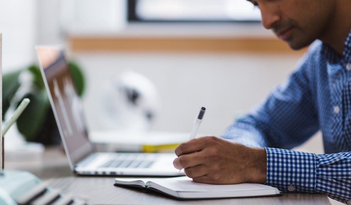 Man die zijn laptop opruimt en bestanden organiseert aan een bureau