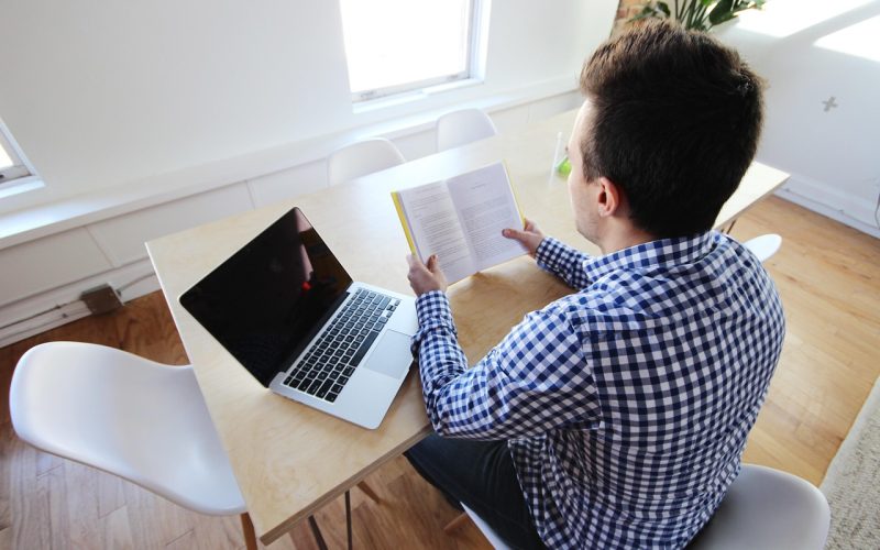 Man achter laptop die salarisdata vergelijkt op verschillende websites