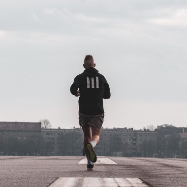 Hardloper op een donkere herfstavond met reflecterende kleding op een natte weg