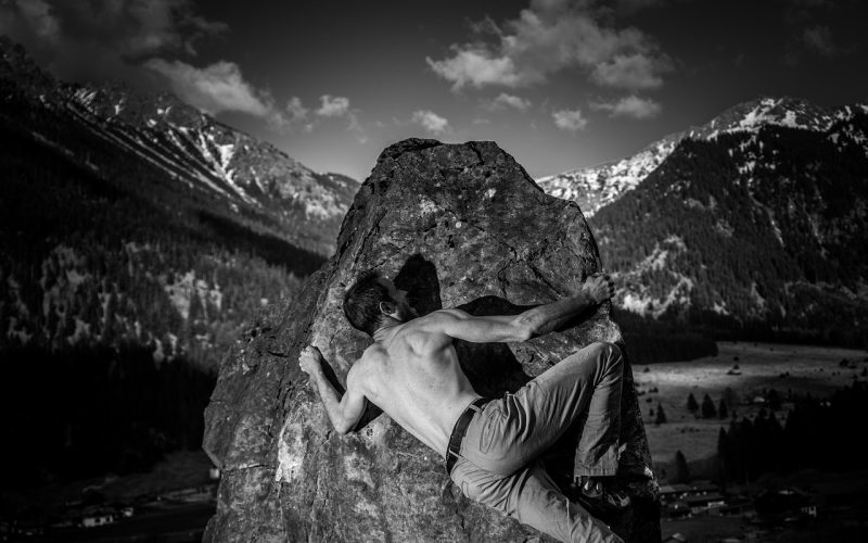 Man klimt op een boulderprobleem in een klimhal tijdens de winter
