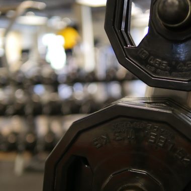Man die gewichten tilt in een eigen thuisgym in de garage
