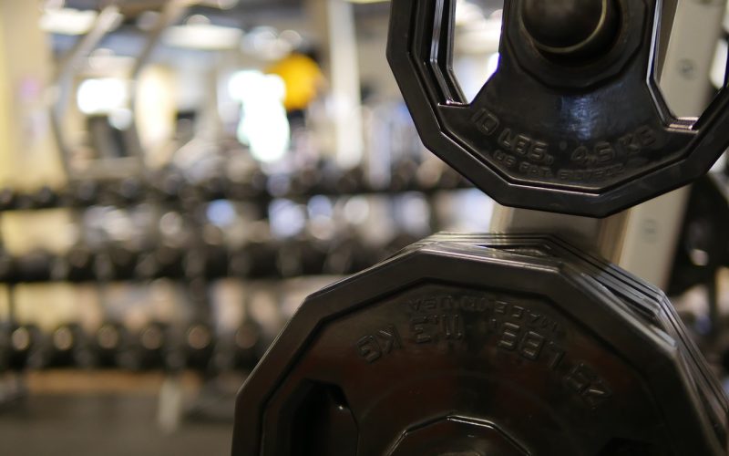 Man die gewichten tilt in een eigen thuisgym in de garage